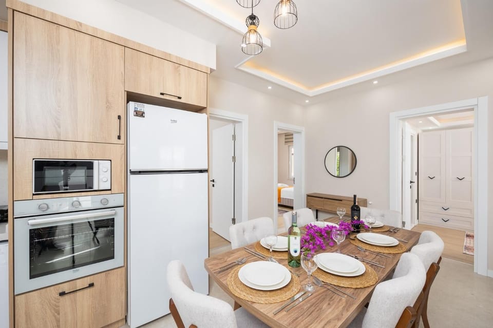 Open-plan living room with sofa, dining area, kitchen, A/C, WiFi internet, and satellite TV