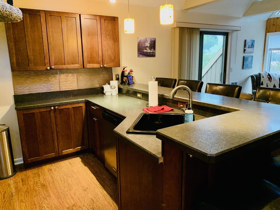 Extended part of kitchen with larger counter space and bar stools.
