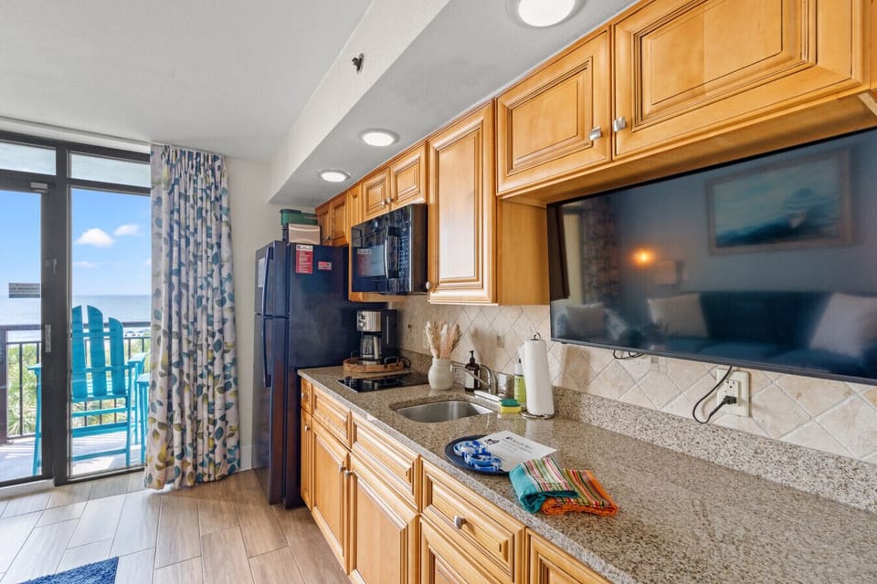 Beachfront living room perfect for unwinding after a day in North Myrtle Beach. Lounge on the cozy sofa, take in ocean views, or relax on the balcony overlooking the pool and waves. Features a queen sleeper sofa for extra comfort and space.