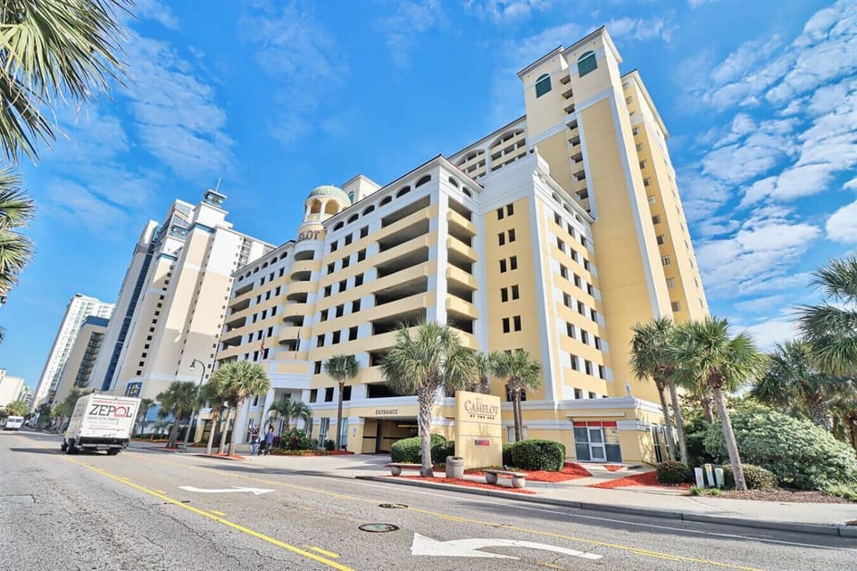 Exterior street view of Camelot by the Sea Resort on the main strip in Myrtle Beach, close to the Boardwalk, SkyWheel, beach access, dining, and top attractions.