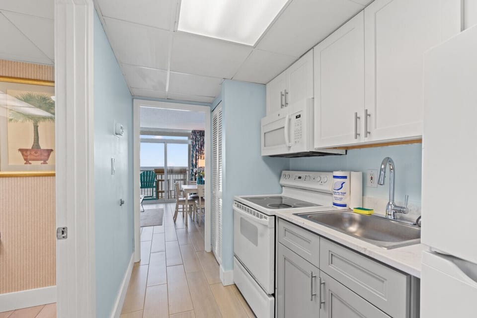 Remodeled full kitchen with fresh countertops, deep oversized sink, stove, oven, microwave, full-size fridge, Keurig, drip coffee maker, cookware, dishware, and silverware for easy vacation meals.