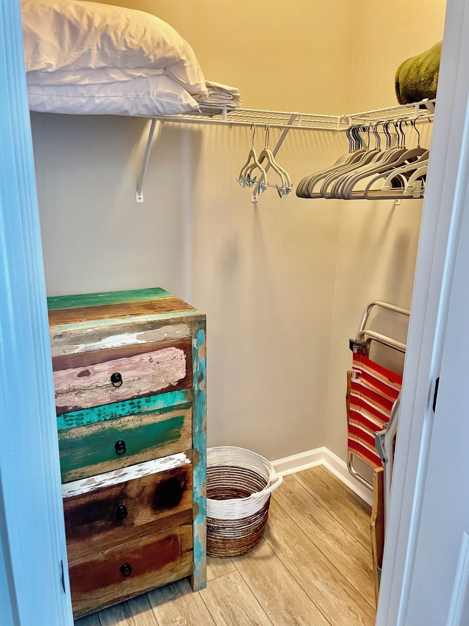 A walk in closet with plenty of storage and hangers for your clothing needs. 