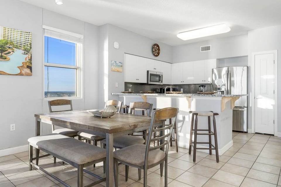 Modern kitchen and dining area with ocean views through the window.