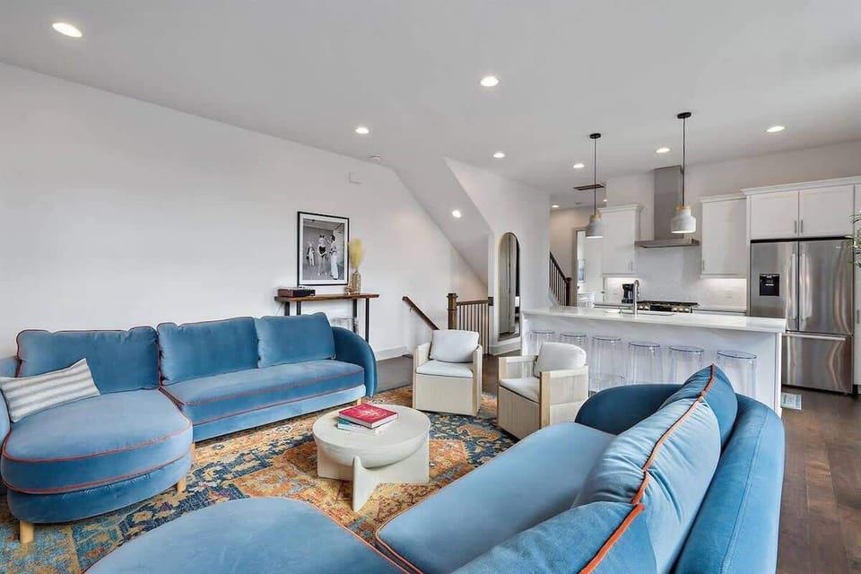 Relax in a spacious living room with cozy blue couches and seating!