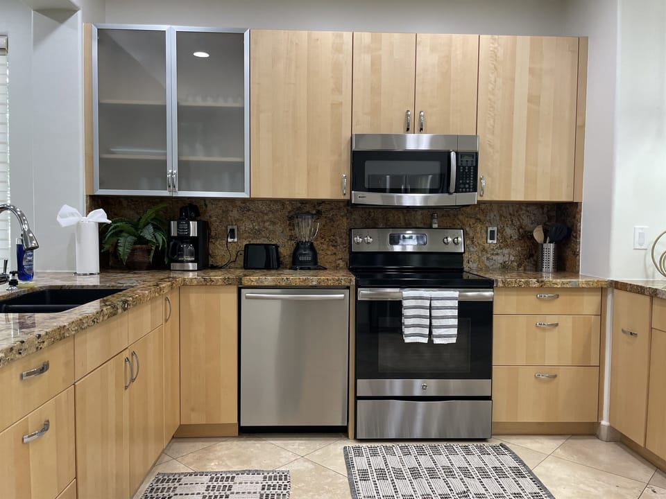 Fully-equipped kitchen with dishwasher, refrigerator, freezer with ice maker, 4-burner stovetop, microwave, oven and pantry.