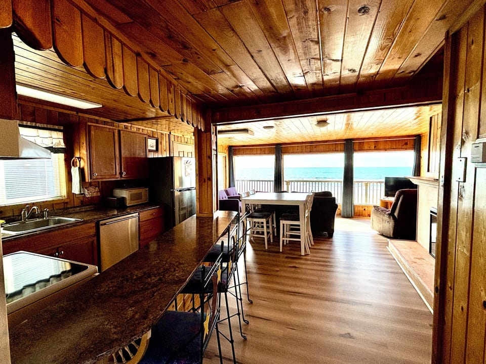 Open-concept kitchen, dining, and living area with panoramic ocean views