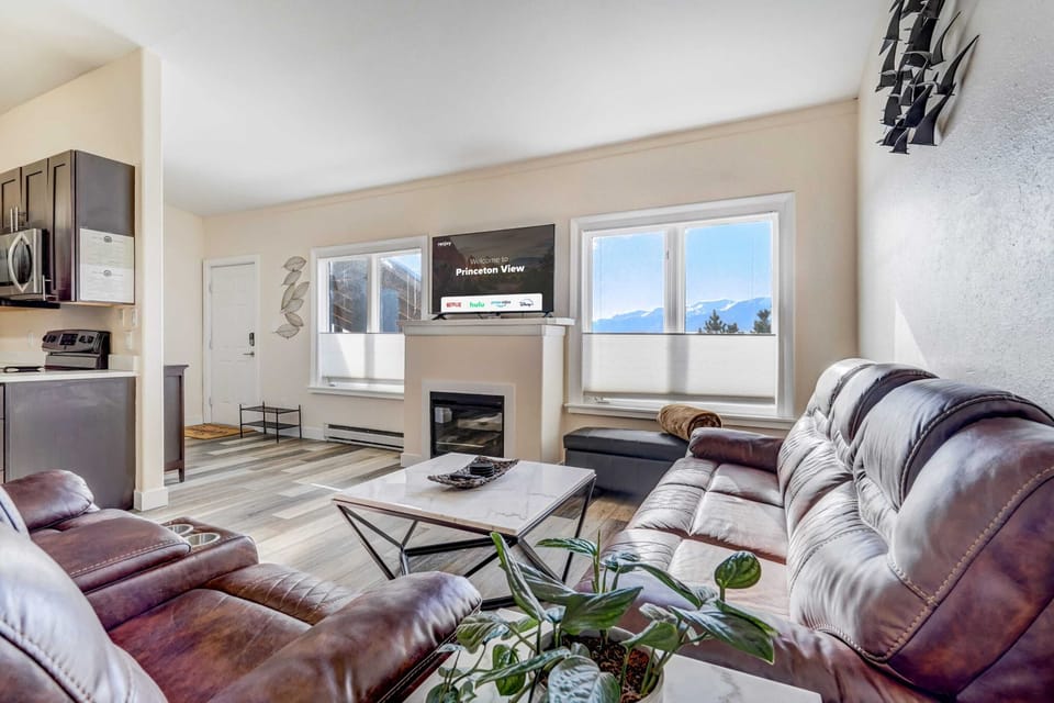 Welcome to Princeton View! In the inviting living room, a cozy sofa awaits. Enjoy the warmth and ambiance while catching up on your favorite shows or movies on the smart TV. The stylish decor adds a touch of charm to this perfect spot for unwinding.