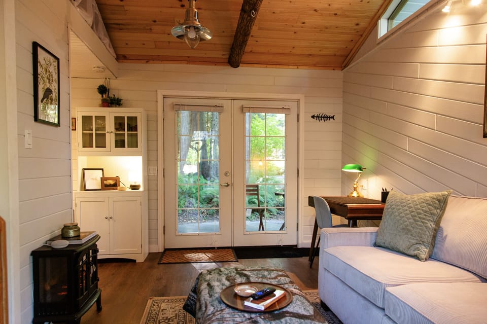 The main space of the cabin, with pull-out couch, TV and workspace.