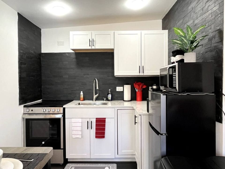 Kitchen is fully equipped with smaller range, microwave, fridge, coffee pot, and tea kettle