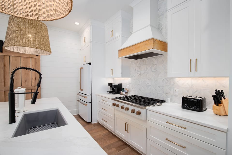 Cook your favorite meals in this stunning modern kitchen with premium appliances and elegant marble backsplash.