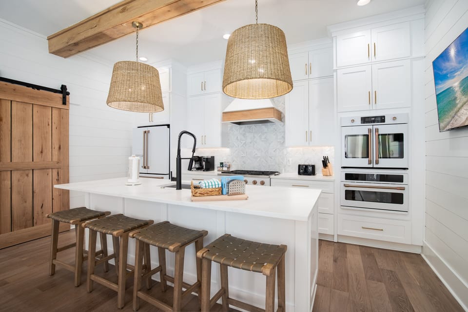 Your fully equipped gourmet kitchen features elegant white cabinetry, premium appliances, and a spacious island where you can cook and gather.
