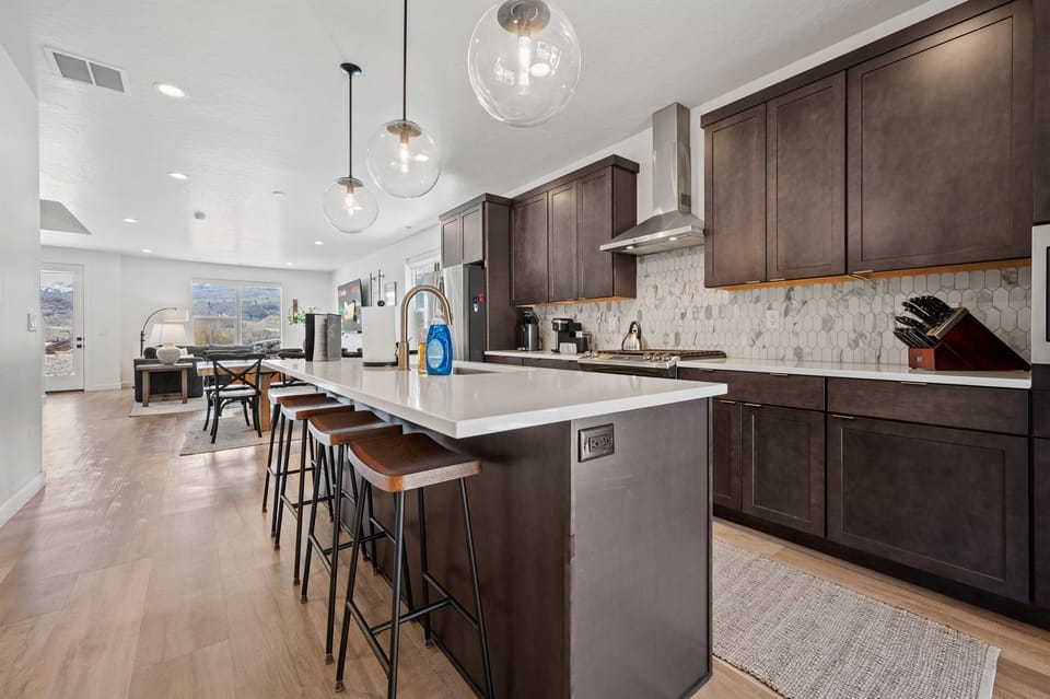 With its modern lighting, windows, quartz countertops, and stunning backsplash, the kitchen makes preparing dinner a truly enjoyable experience.