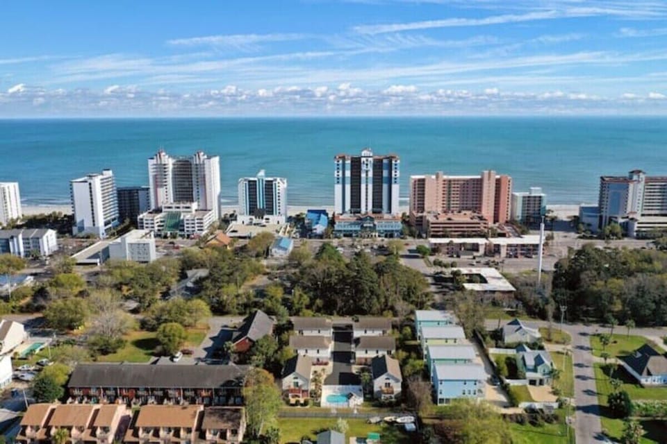 Aerial view of vibrant neighborhoods, oceanfront towers, and sea horizons.