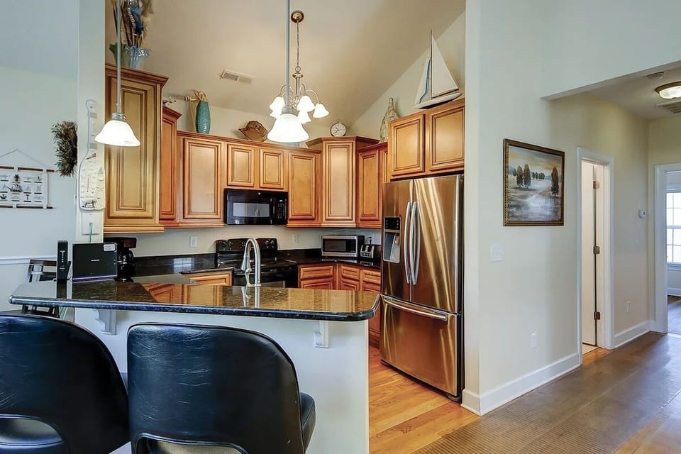 Modern kitchen with granite, stainless appliances, and sleek breakfast bar