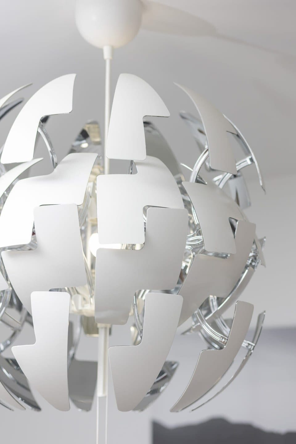 A close-up of a decorative ceiling lamp with an abstract white design, adding an artistic touch to the interior.
