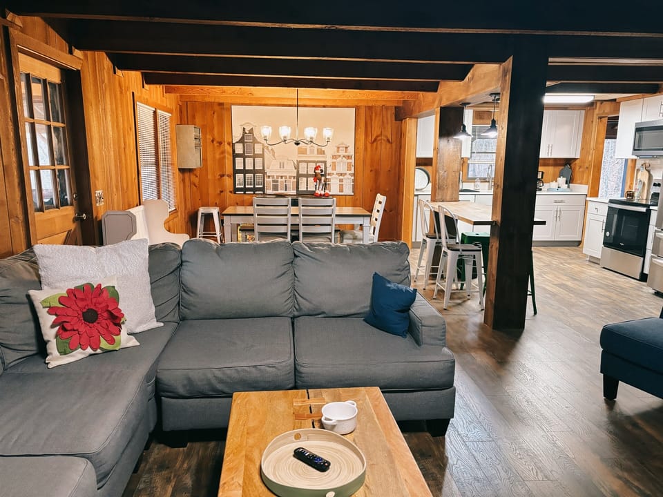 Cozy, open-concept living space featuring warm wood accents, comfortable seating, and a bright dining area—perfect for gathering and relaxing together.