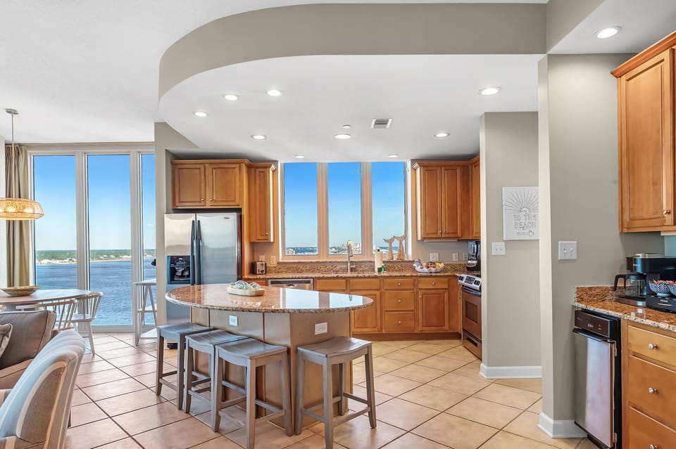 Spacious open-concept kitchen w 4 barstools at island.