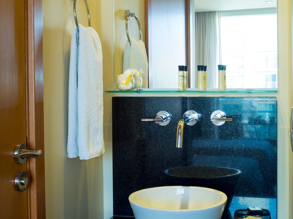A broad mirror and open glass shelf put towels and toiletries close at hand.