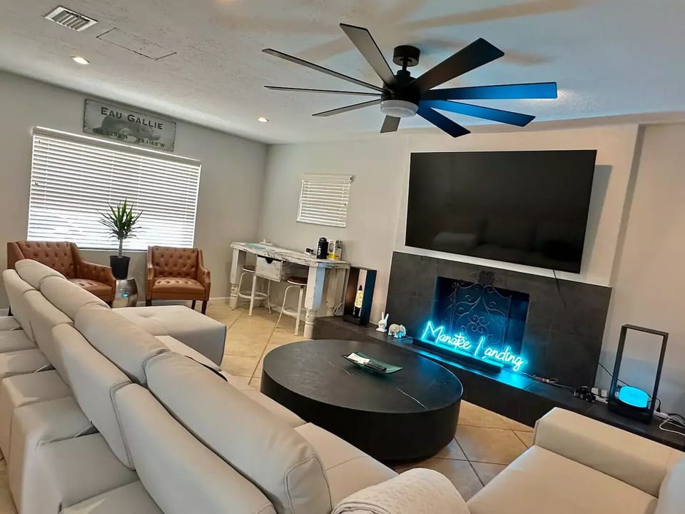 Media room with 85" TV and reclining sectional.