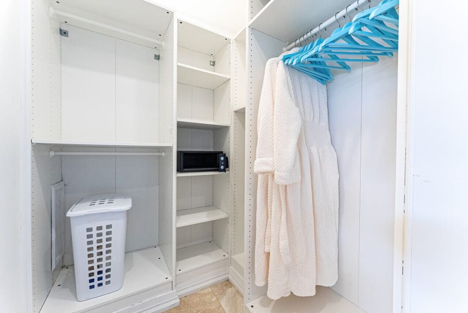 Primary bedroom walk-in closet w/ robes & safe