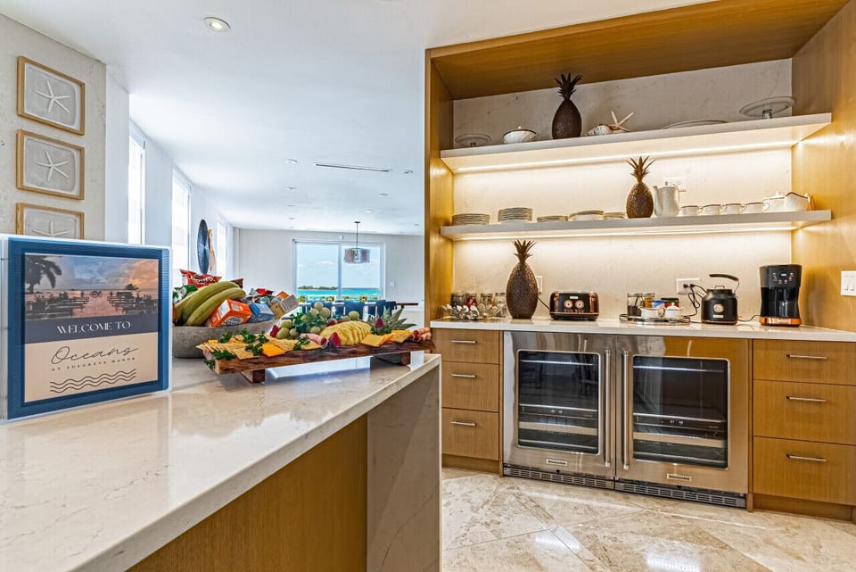 Coffee bar featuring 2 wine fridges, kettle, coffee maker, variety of teas & coffee