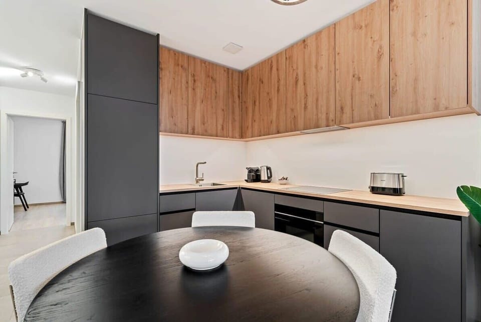 Prepare your meals with ease in our fully equipped kitchen, featuring modern appliances and a sleek design.