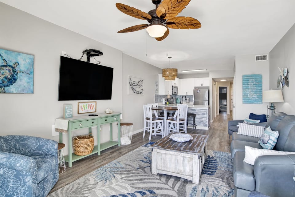 Living room with a leather sleeper sofa, 3 armchairs a wall mounted smart TV and a breathtaking Gulf view!