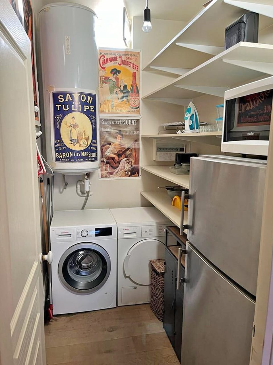 The room with the washing macine, dryer, microwave and kitchen/freezer