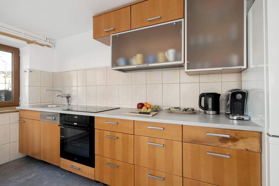 A fully equipped kitchen with wooden cabinets and built-in appliances. The space is practical and well-organized.
