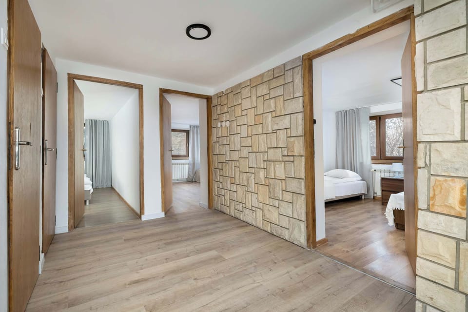 A wide hallway with wooden floors and stone wall accents. The area creates a welcoming first impression.