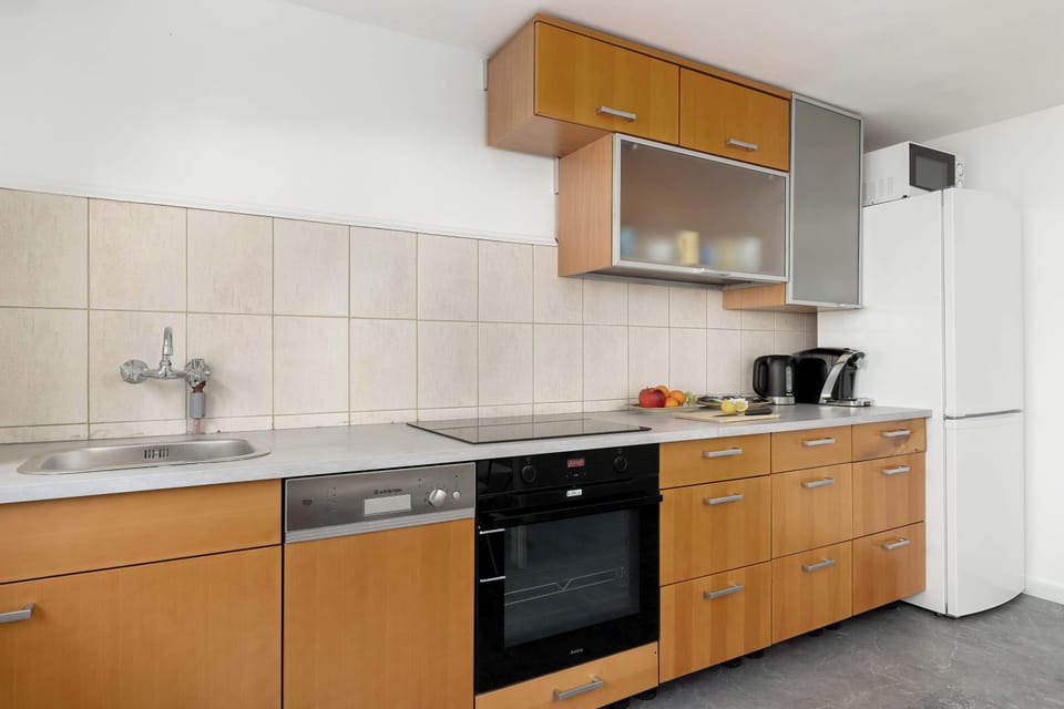 A modern kitchen with a dishwasher, oven, and countertop space. The layout allows for comfortable meal preparation.