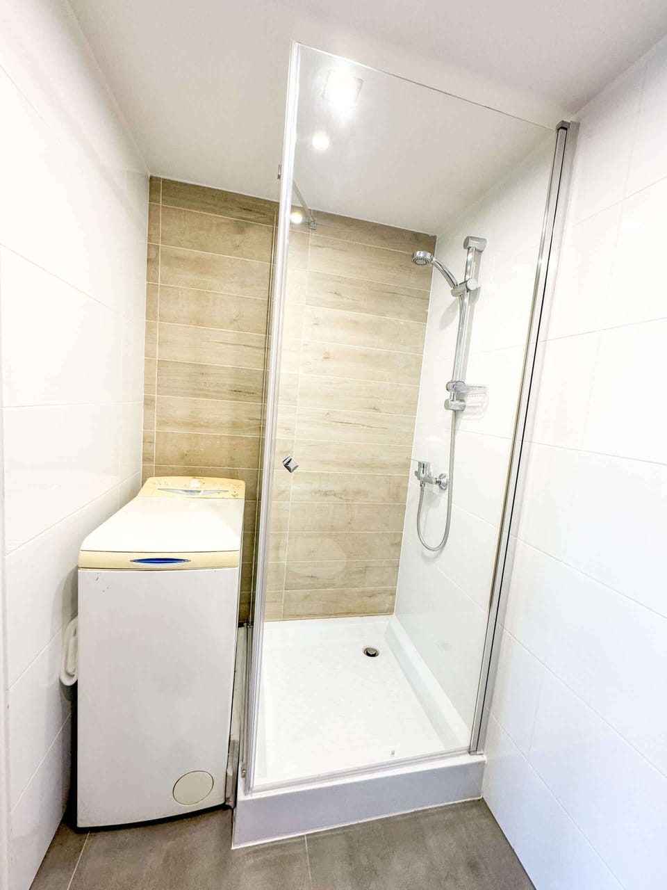 A modern bathroom with a walk-in shower, wooden tiles, and minimalist fixtures, offering a sleek and elegant design.






