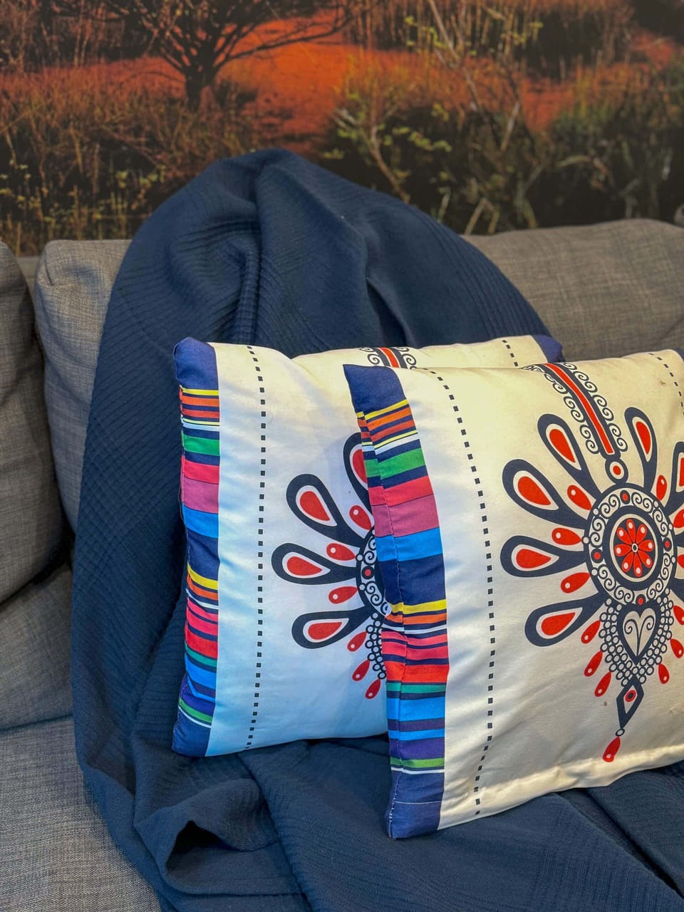 A close-up of a blue sofa adorned with colorful embroidered cushions, enhancing the living space's coziness and cultural flair.
