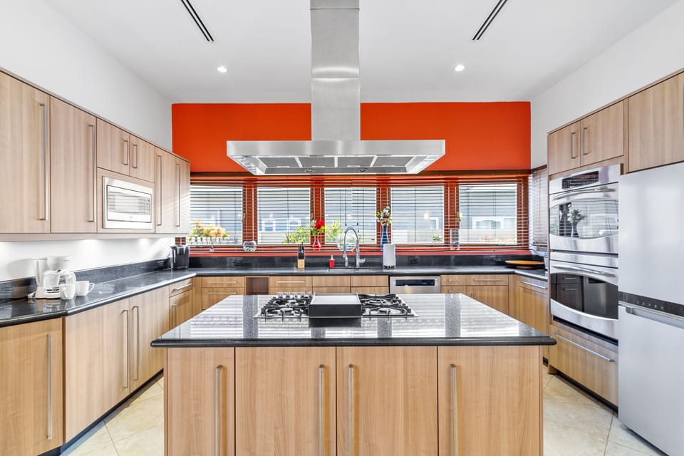 Kitchen features granite countertops, stainless steel appliances, and pristine white cabinetry