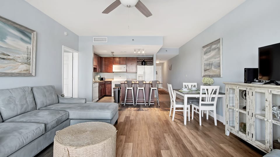 Open-concept living area with modern kitchen and dining space featuring wood flooring.