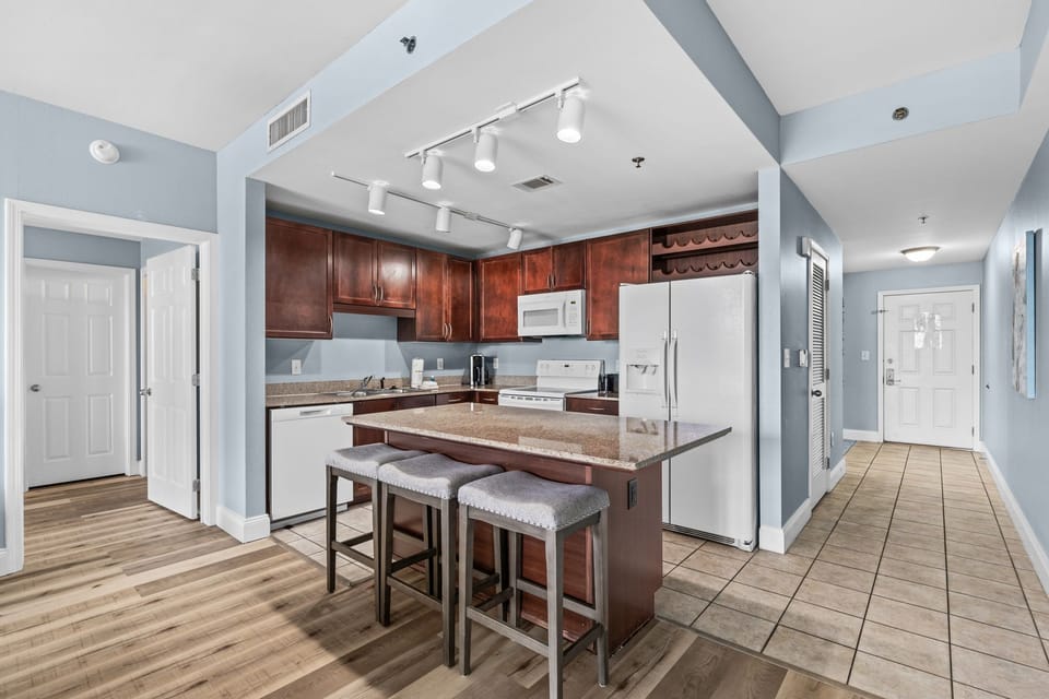 Step into your private bathroom, where soothing blue walls meet warm wood vanity and cheerful botanical accents. Fresh towels await, and bright natural light makes every morning feel fresh.