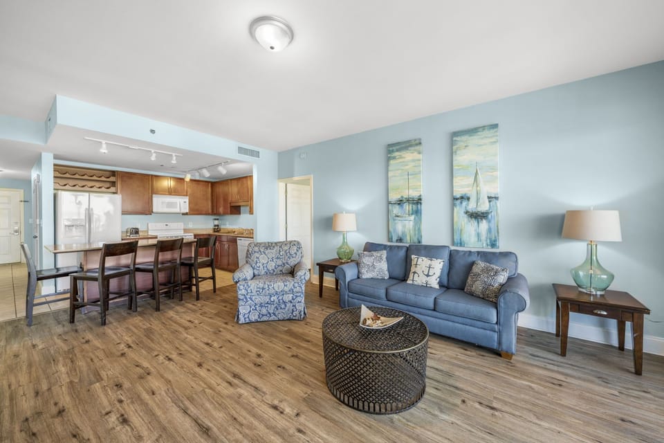 Open-concept living area with coastal-inspired decor and a fully equipped kitchen.