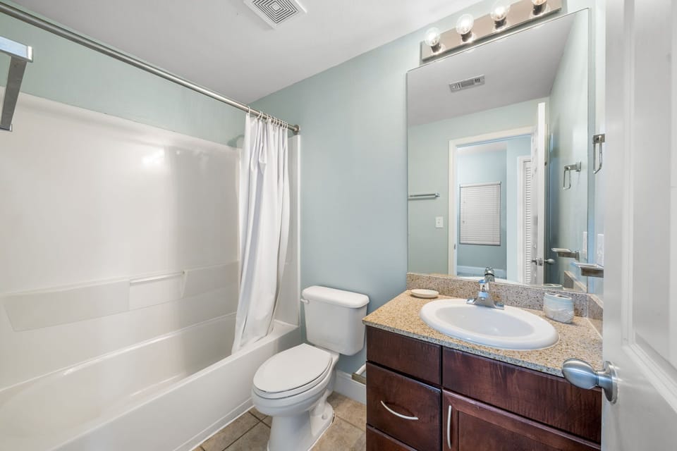 Clean bathroom with a bathtub and granite countertop vanity