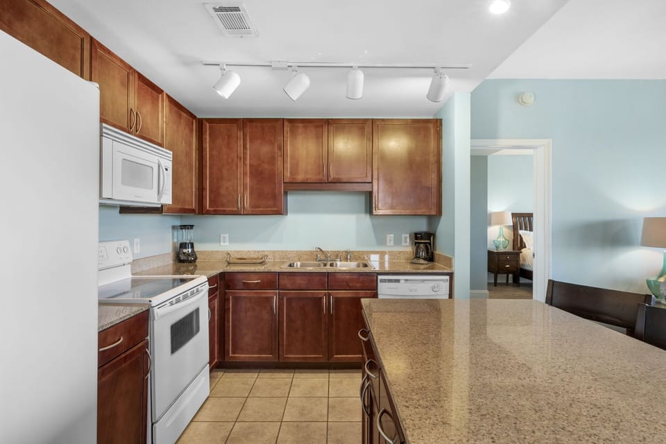 Modern kitchen with wooden cabinets and granite countertops.