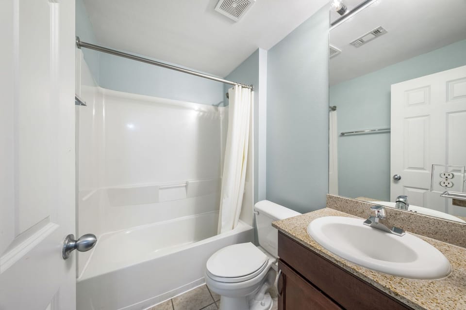 Clean bathroom with a bathtub and shower combination in a modern setting.