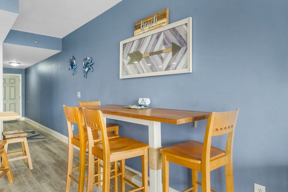 Cozy dining area with wooden chairs and a blue accent wall featuring nautical decor.