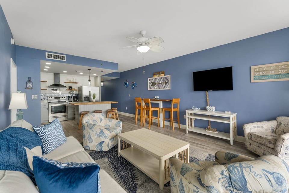 Open-concept living area with coastal-inspired decor and a fully equipped kitchen