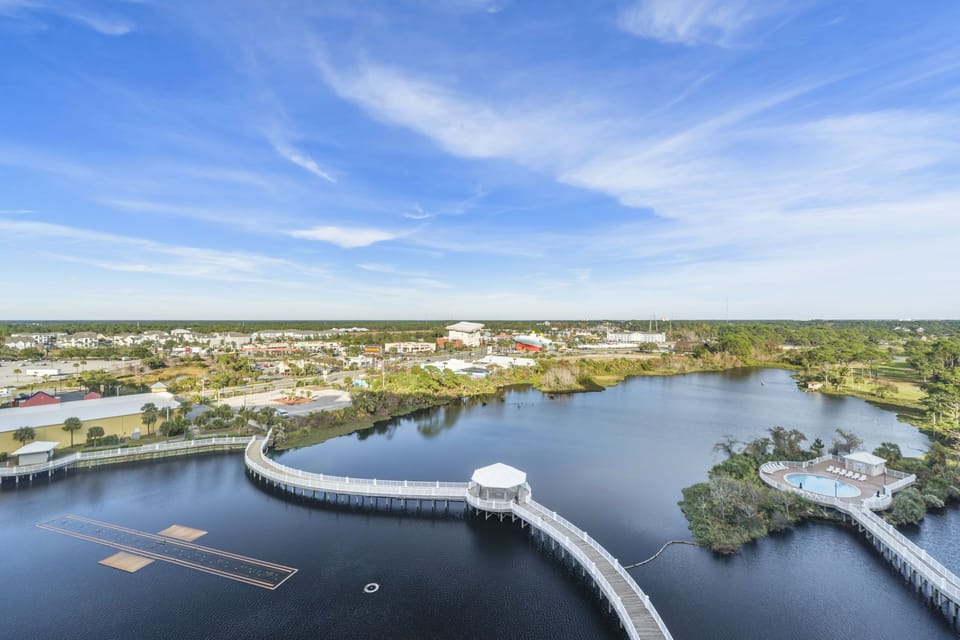 Scenic waterfront view with a curved boardwalk and surrounding greenery