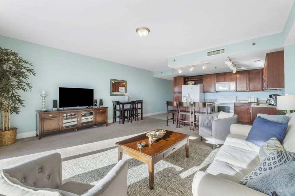 Spacious living area with natural light and an open kitchen featuring wooden cabinetry.