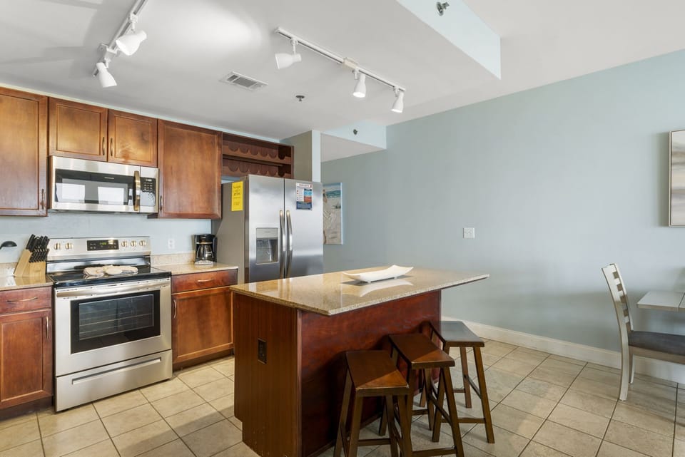Modern kitchen with stainless steel appliances and a central island for casual dining.