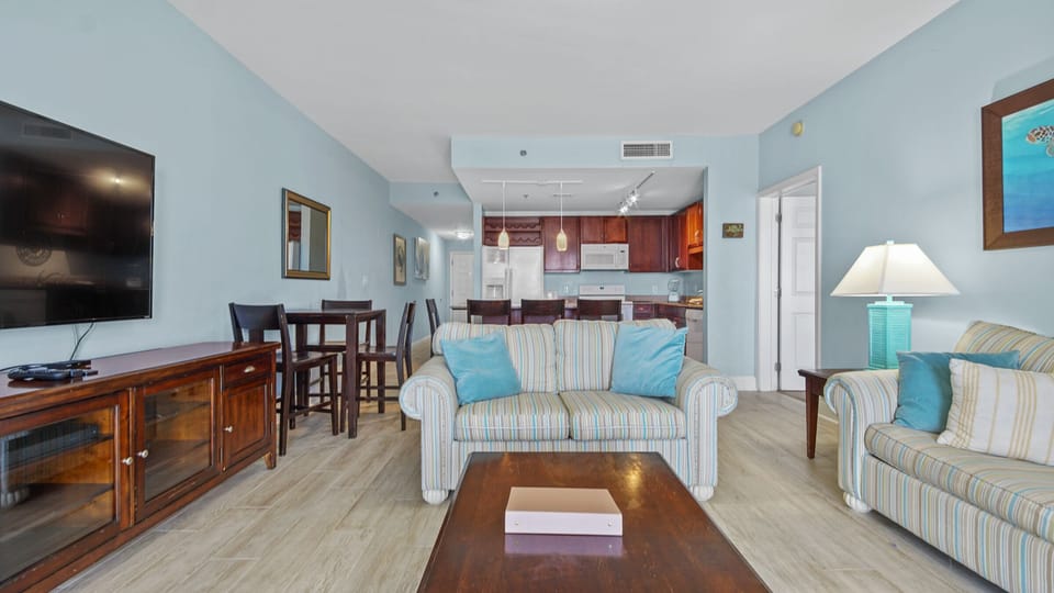 Open living area with striped sofa and kitchen in the background