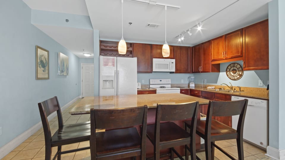 Modern kitchen with wooden cabinetry and a large island for casual dining.