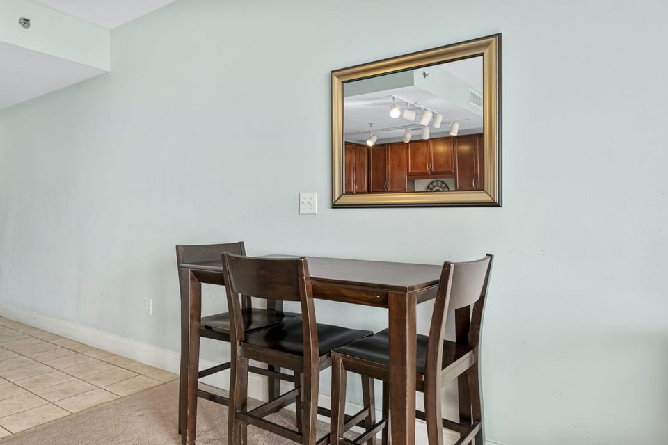 dining area with dark wood table and chairs under a large framed mirror