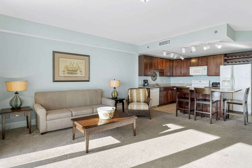 Open living area with natural light and a kitchen featuring dark wood cabinets