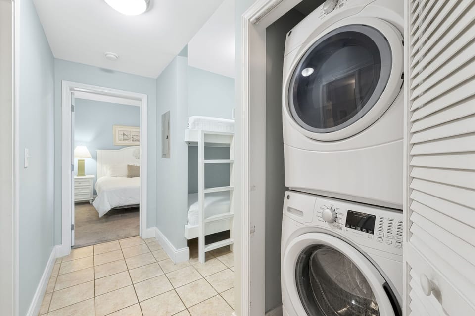 Stacked washer and dryer in a hallway near the bedrooms for convenient laundry access.